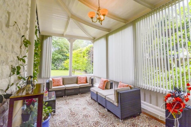 This bright and airy orangery is another relaxing space on the ground floor of the Crow Hill Drive property. It has an exposed stone feature wall, windows overlooking the grounds and doors leading both outside and into the hallway.