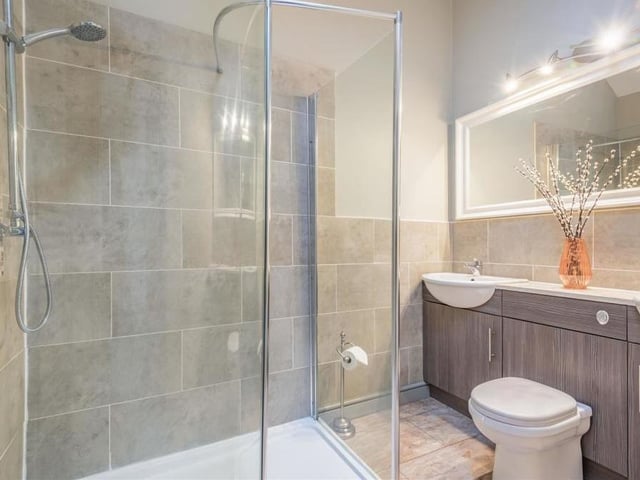 The en suite to the master bedroom is very much de rigueur and made up of a contemporary, white four-piece suite with chrome fittings. There is a walk-in, tiled shower enclosure, large vanity unit with his and her sinks and mixer taps, central work surface and cupboards, low-flush WC, heated towel-rail and Velux roof window.