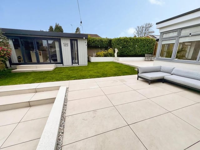 A fully insulated garden room with sliding doors and a built-in bar creates a perfect year-round entertaining space or home retreat.