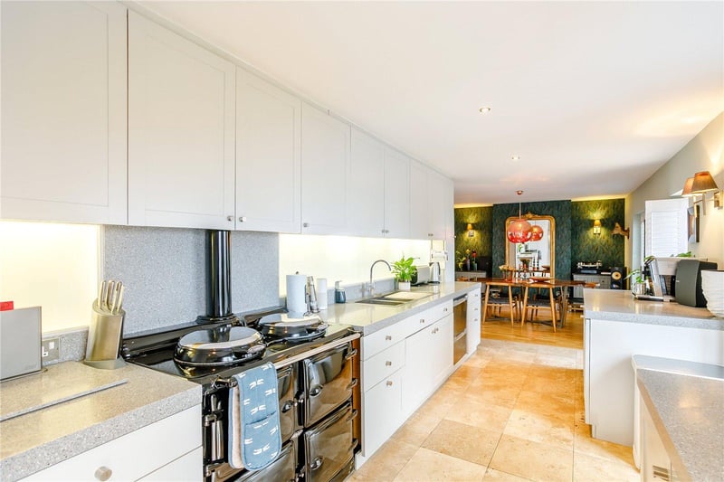The kitchen incorporates a range of light grey base and wall units with Silestone worktops and a range of appliances.