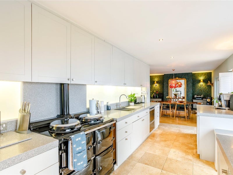 The kitchen incorporates a range of light grey base and wall units with Silestone worktops and a range of appliances.