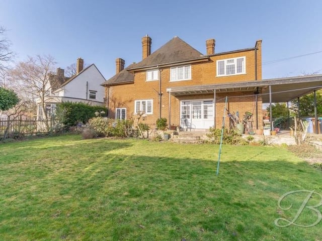 The extensive garden at the back of the £560,000 house contains a lawn, patio seating area, shrubs and trees. You can see the sliding doors that lead out from the utility room and, to the far left, those that lead from the lounge.