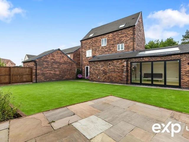 The landscaped rear garden is both generous and low maintenance, with a large patio area, artificial lawn and a charming patio area with pergola overlooking open green space—perfect for outdoor entertaining or peaceful relaxation.