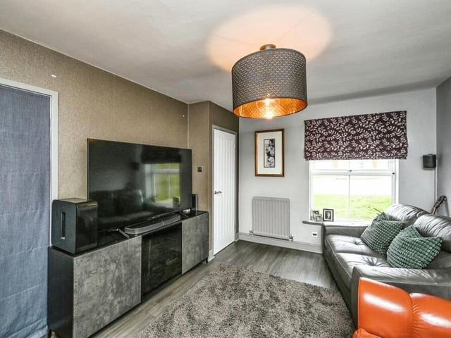 A second reception room on the ground floor is this cosy lounge, which faces the front of the property. Features include a laminate floor, a storage cupboard and an archway leading to the kitchen/diner.