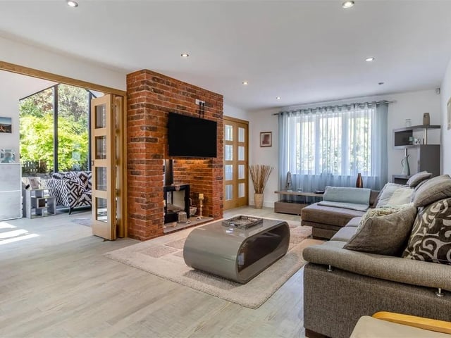 Large, 9m dual aspect open plan living/dining room featuring a beautifully appointed brick fireplace with dual log burner.