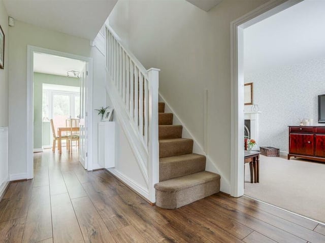It's time to check out the first floor now, so let's pass through the inviting entrance hallway, which has wood-effect flooring and a carpeted staircase.