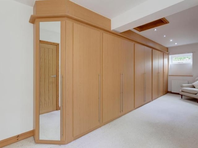 Many department stores would be delighted with this huge dressing area, which is attached to the master bedroom. It incorporates a range of fitted furniture, storage space and shelves. There is also access to the loft.