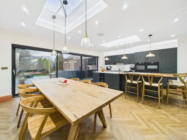 The open plan living area is flooded with natural light from two striking ceiling lanterns with inset lighting and expansive aluminium powder-coated sliding doors that provide seamless access to the rear garden.
