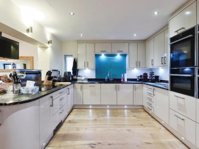 The sparkling kitchen boasts top-of-the-range appliances, such as a rising extractor fan, two hide-and-slide ovens, a combi-microwave, a steamer, under-counter fridge, double fridge freezer, wine fridge, induction hob and waste disposal system.