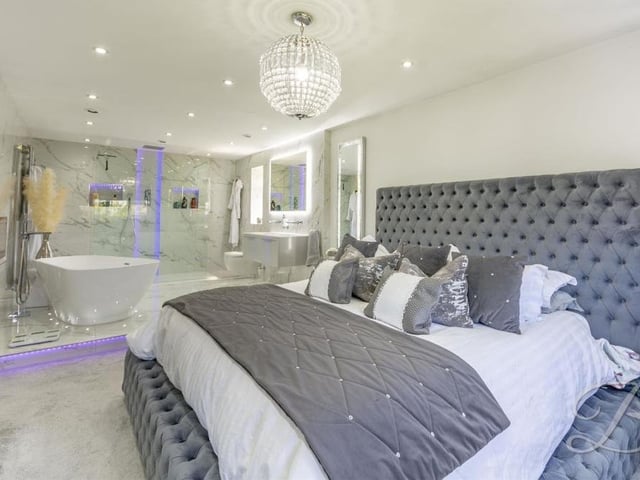 The master bedroom at the Kirkby property is a sight to behold and a perfect example of the high-quality fixtures and fittings so apparent throughout the house. It boasts a carpeted floor, underfloor heating and downlights, and in the background, you can see its en suite bathroom.