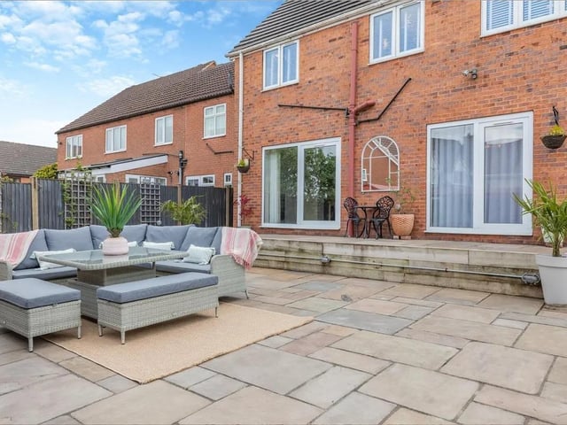 The low maintenance garden laid to substantial Indian sandstone patio has an adjoining garden store to the other side and a summerhouse with an adjoining undercover decked area to the side.
