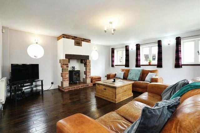 Let's kick off our tour of the unique £525,000 property in the lounge, which is not only full of space but also full of character with its wood-burning stove, exposed brick walls and solid wood flooring.