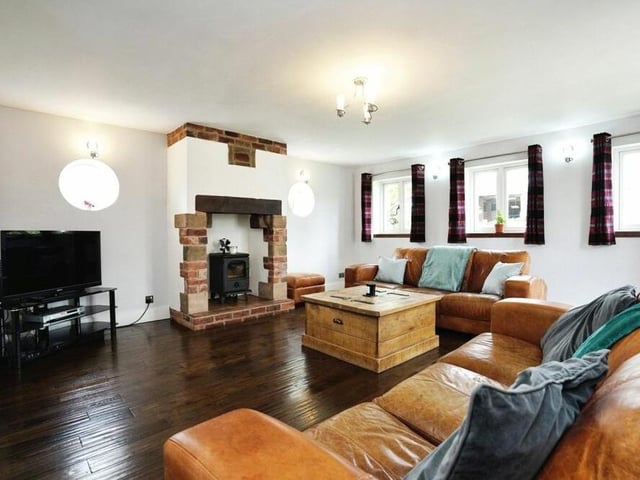 Let's kick off our tour of the unique £525,000 property in the lounge, which is not only full of space but also full of character with its wood-burning stove, exposed brick walls and solid wood flooring.