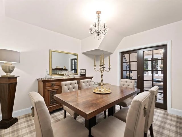 The dining room is perfect for hosting dinner parties with double doors leading to the entrance hall and an additional side door with carpeted flooring and a radiator.