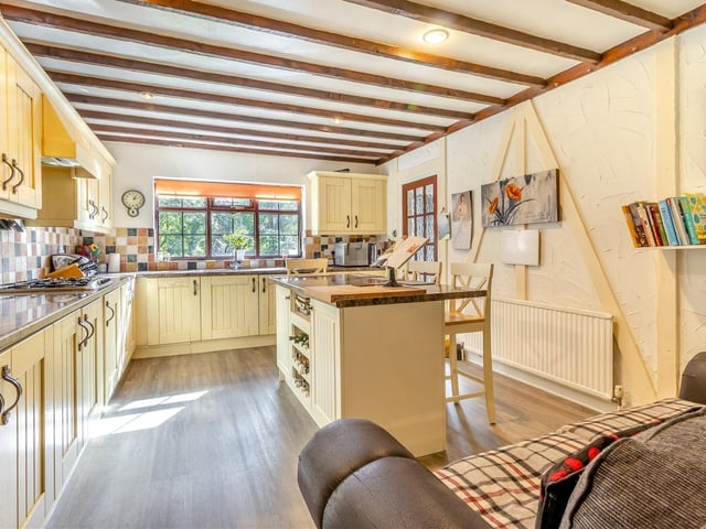 One striking feature of the kitchen/breakfast room is its beamed ceiling, enhancing the character of the £535,000 property. A central island contains more base units, plus a wine rack and space for stools on either side.