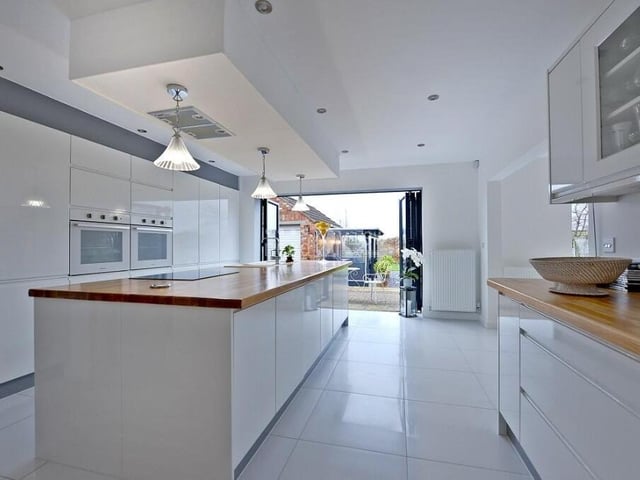 The contemporary kitchen, which comes complete with bi-folding doors that open out on to the back garden, oozes class and style. It is fitted with a range of wall and base units in a white gloss finish.