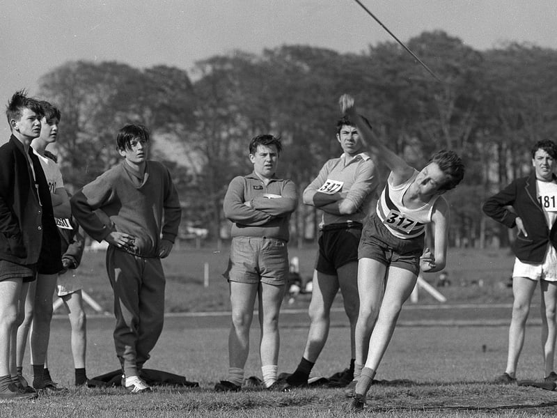 Pupils look on as one competitor throws the javelin during a competition for secondary school pupils back in 1962.