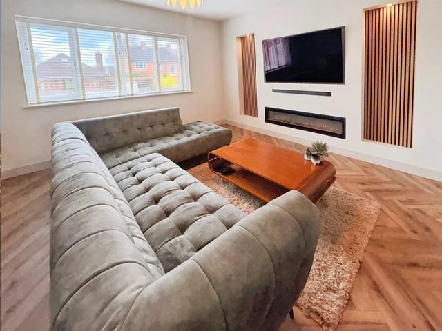 The lounge features a bespoke media wall with an inset electric fire and underfloor heating, creating a warm yet minimalist environment.