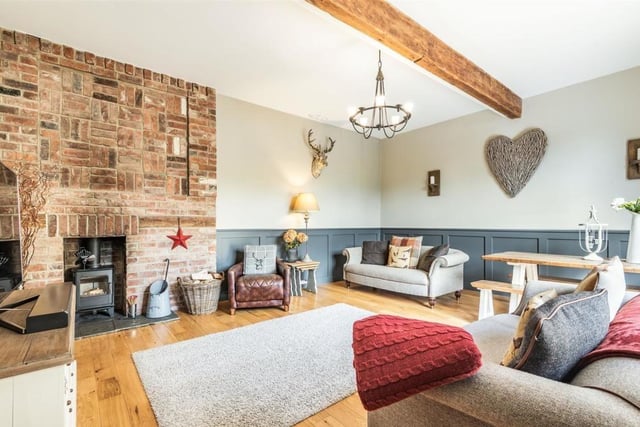 The lounge also features a beautifully appointed brick fireplace and chimney breast extending from the floor to the ceiling, with an inset log burner and attractive stone hearth.