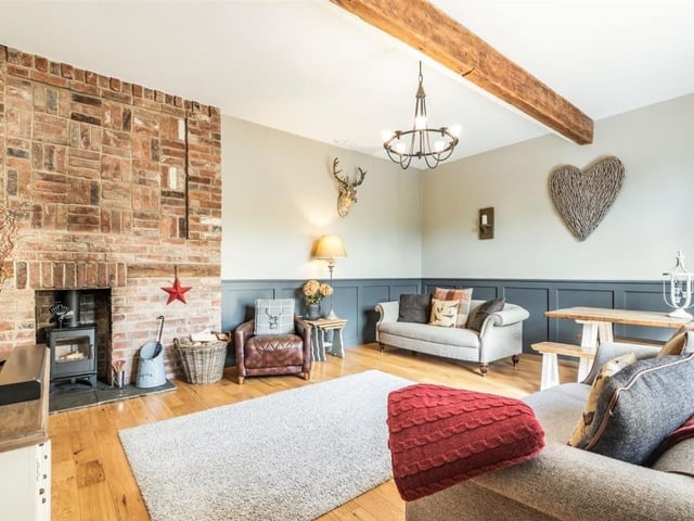 The lounge also features a beautifully appointed brick fireplace and chimney breast extending from the floor to the ceiling, with an inset log burner and attractive stone hearth.