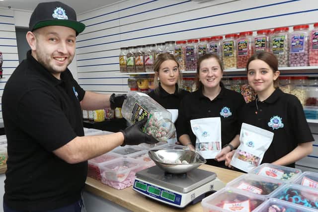 Bradley Mower with his wife Rebecca and daughters Lillie and Chloe inside his new Mr Munchies store.