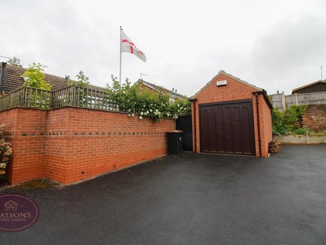 Gated access to the house leads directly to this detached and sturdy single garage. It sits at the end of a large driveway that provides off-street parking space for many vehicles.