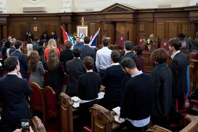 Attendees stand up and swear an oath at a British citizenship ceremony.