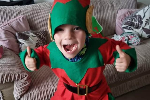 Excited Christmas elf Billy Dawes aged six who walked eleven miles on a sponsored walk with his mum Eve Dawes