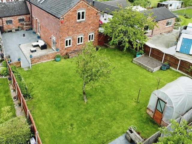 We close our gallery with a revealing aerial shot of the south-facing rear garden, which is made up of fruit trees and a large lawn.