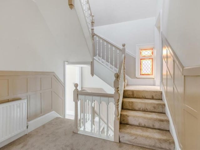Time to move upstairs now at the Crow Hill Drive property. The first-floor galleried landing is a continuation from the hallway, with painted, panelled walls. A stained glass window adds a touch of charm.