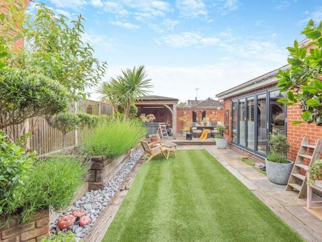 Let's step outside now for our first look at the south-east facing, landscaped garden at the back of the £465,000 house. It is low maintenance, featuring an artificial lawn, pathways, mature plants and shrubs and brick-built railway-sleeper planters.