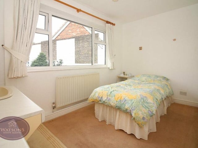 This second bedroom also features fitted wardrobes and a vanity sink unit. It faces the back of the bungalow.