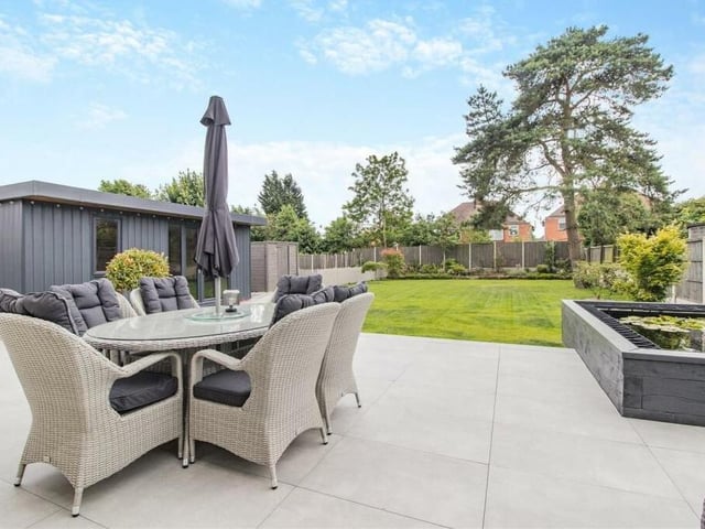 Here is a close-up of the substantial porcelain patio, with space for seating, in the rear garden. It is an ideal spot for relaxing with a cuppa or a glass of wine, or for entertaining friends. To the right, you can see the garden pond and in the background is the garden room.