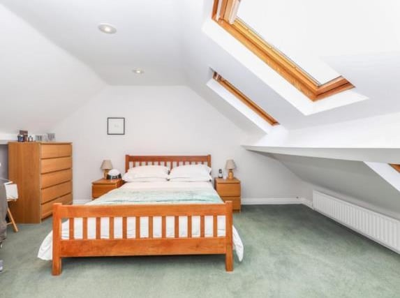 The attic bedroom is described by the estate agent as a 'fabulous room' - it has rear-facing Velux-style windows and access to the en-suite bathroom.