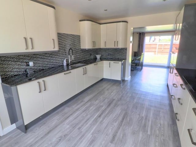 The hallway leads into this impressive kitchen, which has just been refitted with cream gloss matching units and drawers with granite worktops, sink and drainer, and splashback tiling.