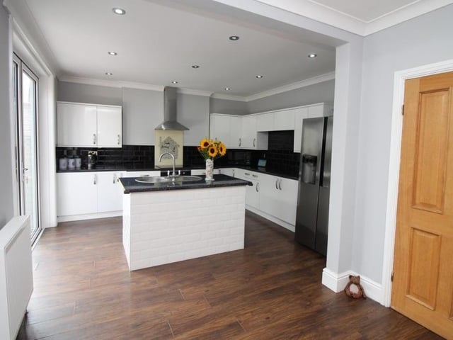Let's begin our tour of the Nottingham Road house in the dining kitchen, which is fitted with a range of modern, matching high-gloss wall and base units, plus complementary work surfaces. Textured wooden flooring adds a touch of class
