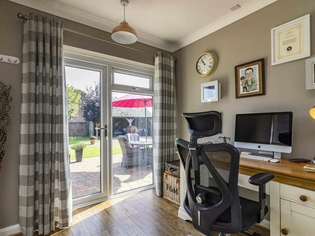 The fourth bedroom, which has doors opening out to the garden, has been converted by the current owners into a smart home office.