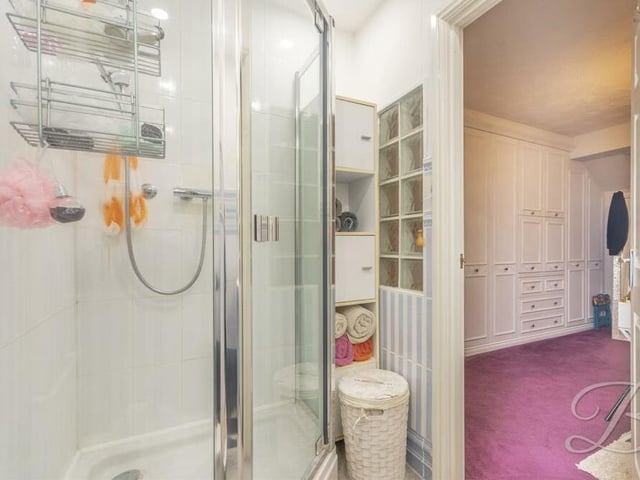 The second bedroom also has access to an en suite shower room, complete with walk-in shower cubicle, low-flush WC, vanity hand wash basin and chrome, heated towel-rail.