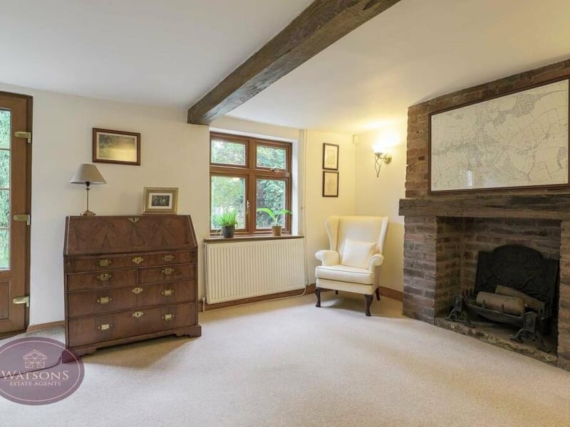 The front door of the property leads into the sitting room, which also features a storage cupboard.