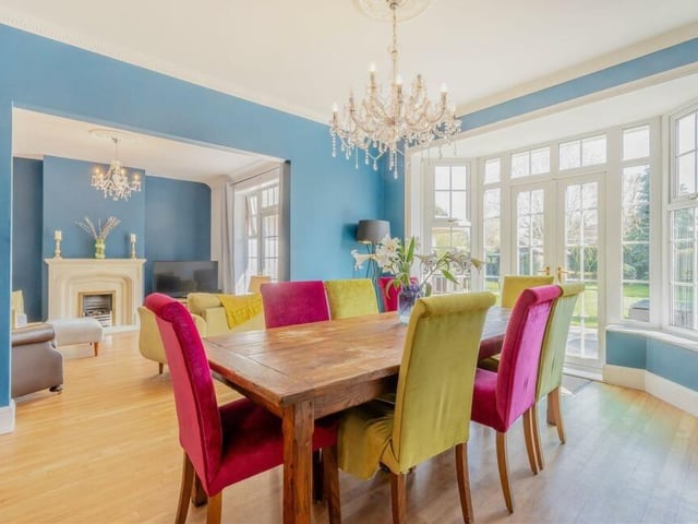 Next to the lounge is this cheerful dining room, complete with a bay that features two large windows and French doors leading out to the garden. There is also a wood floor and coving to the ceiling.