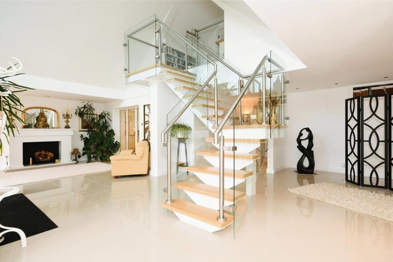 The reception hall contains this modern staircase, which leads to the first floor. It is made of glass, stainless steel and wood.