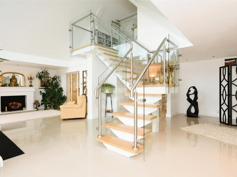 The reception hall contains this modern staircase, which leads to the first floor. It is made of glass, stainless steel and wood.