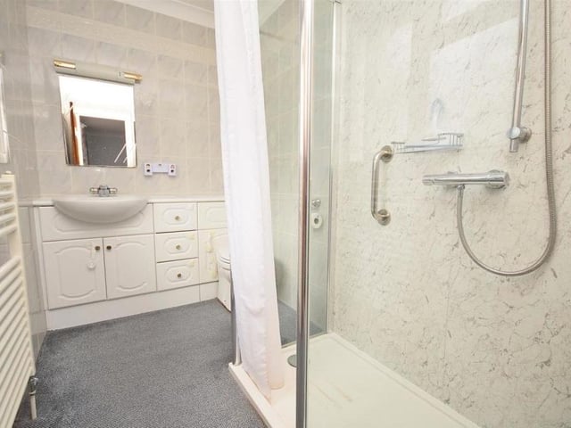 The en suite to the master bedroom comprises a double shower-tray with mixer shower over, wash basin with vanity storage below, and low-level WC with concealed cistern. The room is completed by tiled walls,, a radiator and extractor fan.
