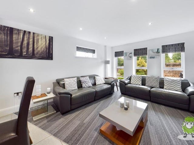 Here is the smart living area or lounge within the open-plan space. There are three windows to the front of the property and one to the side.