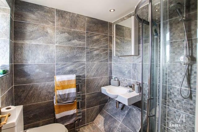 The en suite to the main bedroom is modern and smart. A three-piece suite consists of a walk-in shower cubicle, a wall-mounted wash basin and low-level WC. The floor and walls are tiled, and there is a chrome heated towel-rail.