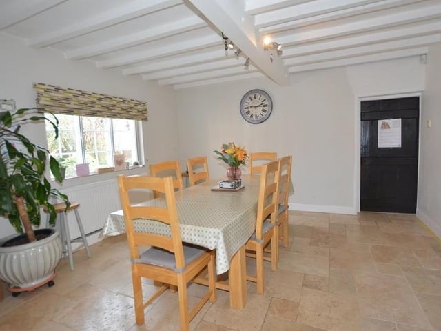 The dining area from a different angle. It is suitable for family meals or entertaining friends. Not far away is a utility room that has wall and base units, an inset sink, plumbing for a washing machine and space for a dryer. It also houses a Glow Worm central heating boiler with unvented hot-water cylinder.