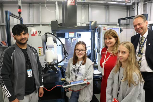 Engineering student Caitlin Massey (second left) operates a Haas VF-2 CNC vertical machining centre with robotic arm, joined by classmates Shameer Qureshi (first left) and Naomi Richardson (front, first right), Kathy Looman and Andrew Cropley.
