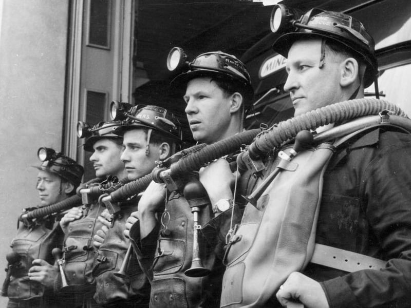 A coal mine rescue team line up for an initial briefing at the scene of an emergency. Trained at the National Coal Board Rescue Station at Mansfield, these men are taught every aspect of mine rescue technique and use every available technology.