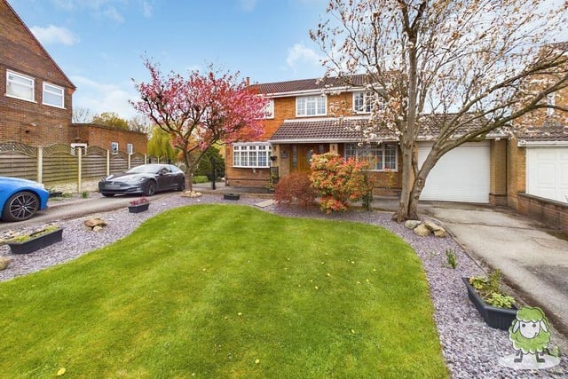 The last photo of our gallery returns to the front of the £995,000 property and shows a twin driveway, lawn and tandem garage.