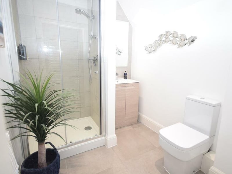 The master bedroom flows through to this luxurious en suite, which comprises a shower cubicle, low-flush WC and wash basin in a vanity unit. Modern fittings and tiled flooring add to its attractiveness.